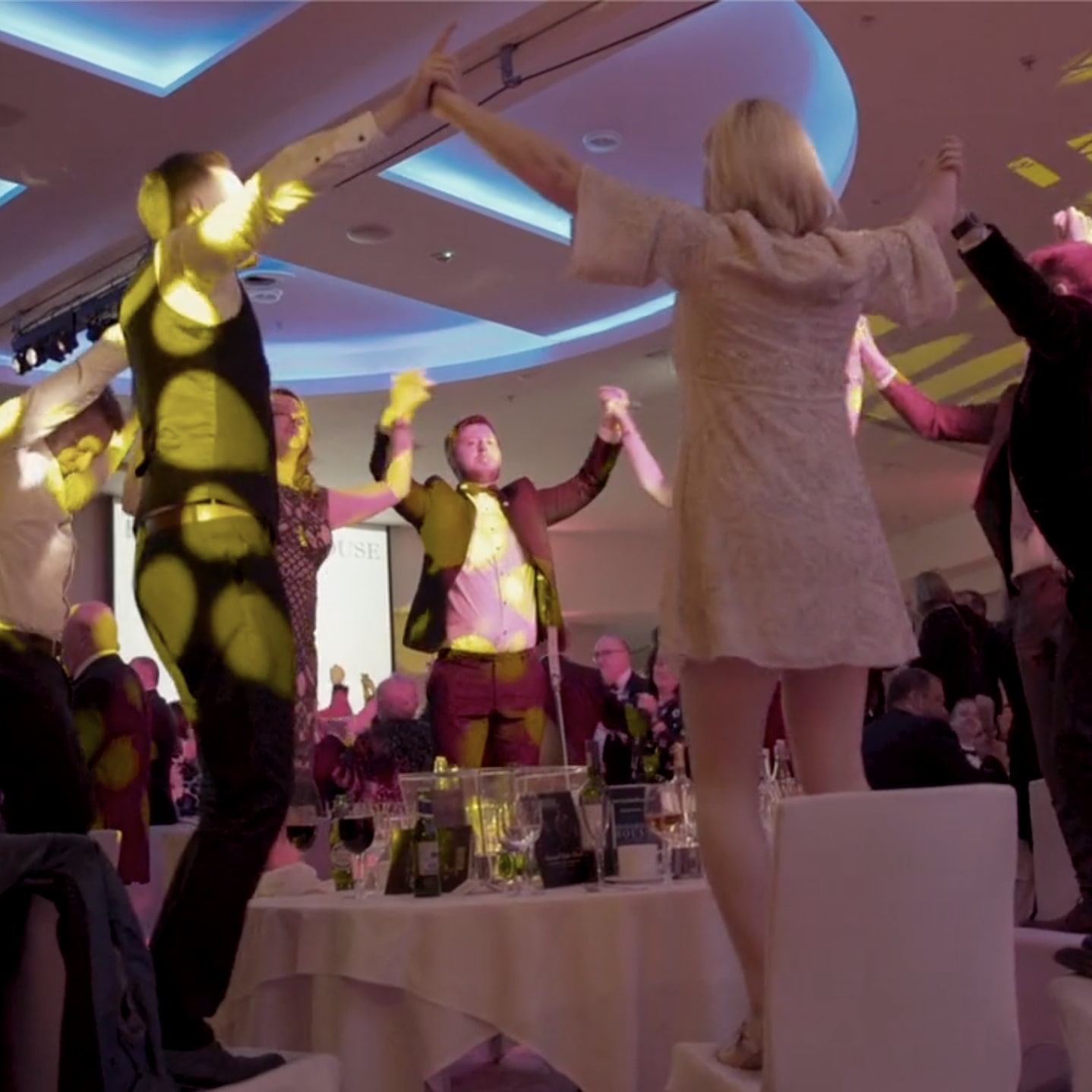 People standing on chairs, dancing