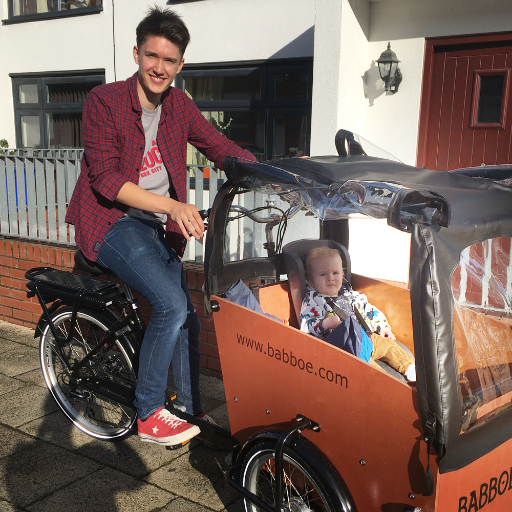 Ben Horrigan riding a cargo bike with a baby in it