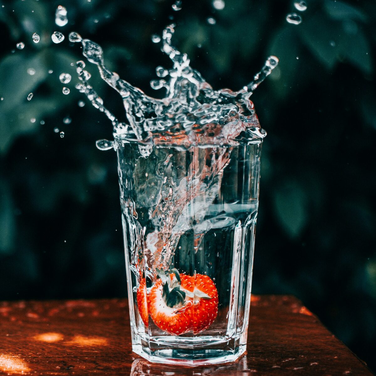 Detailed photo of a strawberry splashing into a glass