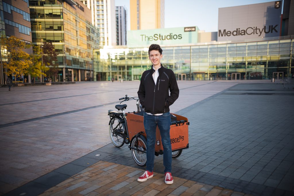 Ben Horrigan standing in Media City with a cargo bike full of camera kit